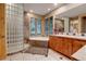 Bright bathroom with stone accents features a soaking tub, large mirror and a glass block shower at 7790 S Homesteader Dr, Morrison, CO 80465