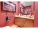 Charming powder room featuring rustic wood cabinetry, decorative fixtures, and a unique bear-themed artwork at 7790 S Homesteader Dr, Morrison, CO 80465