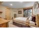 Bedroom with natural wood accents, a neutral color palette, and a window offering serene views of the surrounding landscape at 7790 S Homesteader Dr, Morrison, CO 80465
