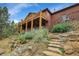 Beautiful backyard featuring a large deck, stone steps, and lush landscaping offering a serene outdoor escape at 7790 S Homesteader Dr, Morrison, CO 80465