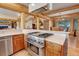 Kitchen with stainless steel range and hood, knotty wood cabinets, and views into the dining area at 7790 S Homesteader Dr, Morrison, CO 80465