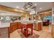 Well-lit kitchen featuring wood cabinetry, stainless appliances, central island, and rustic decor at 7790 S Homesteader Dr, Morrison, CO 80465