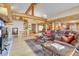 Open-concept living space with wood beams, hardwood floors, and a seamless flow between living and dining areas at 7790 S Homesteader Dr, Morrison, CO 80465