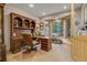 Home office with built-in shelving, a large desk, bay window, and natural light at 7790 S Homesteader Dr, Morrison, CO 80465