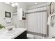 Well-lit bathroom featuring a vanity, cabinet, shower with a white patterned curtain, and modern fixtures at 10546 Sundial Rim Rd, Highlands Ranch, CO 80126