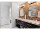 Stunning bathroom featuring dual sinks, marble countertops, designer lighting, and wood paneled accent wall at 10546 Sundial Rim Rd, Highlands Ranch, CO 80126