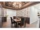 Elegant dining room with decorative wallpaper, wainscoting, a statement chandelier, and hardwood floors at 10546 Sundial Rim Rd, Highlands Ranch, CO 80126