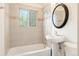 Bathroom featuring tiled walls, a pedestal sink, and updated fixtures at 4972 W Custer Pl, Denver, CO 80219