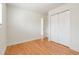 Bright bedroom featuring hardwood floors, closet, and natural light at 4972 W Custer Pl, Denver, CO 80219