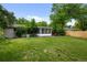 A generous backyard boasts a patio, screen room, mature trees, and green lawn at 6402 Iris Ct, Arvada, CO 80004