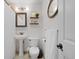 This serene bathroom offers a pedestal sink, floating shelves, and tasteful decor at 6402 Iris Ct, Arvada, CO 80004