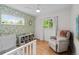 Bright bedroom features modern ceiling fan, leafy wallpaper, and comfy gray chair at 6402 Iris Ct, Arvada, CO 80004