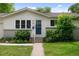 Close up of the front door of a charming home with a well-kept lawn and landscaped shrubs at 6402 Iris Ct, Arvada, CO 80004