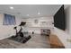 Home gym with exercise bike and TV features sleek flooring and built-in shelving at 6402 Iris Ct, Arvada, CO 80004