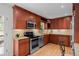 Well-lit kitchen with stainless steel appliances, light countertops, and beautiful wood cabinets at 6402 Iris Ct, Arvada, CO 80004