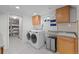 Functional laundry room offers ample storage, a sink, and modern washer/dryer at 6402 Iris Ct, Arvada, CO 80004