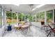 Bright sunroom with tile flooring, all-glass walls, and views of the surrounding yard at 6402 Iris Ct, Arvada, CO 80004