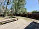 Spacious backyard with deck, wooden bench, wooden fence, mature trees, and green grass perfect for entertaining at 7195 E Louisiana Ave, Denver, CO 80224