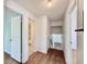 Hallway featuring hardwood floors, a bathroom and stairs leading to another level at 7195 E Louisiana Ave, Denver, CO 80224