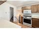 Well-equipped kitchen featuring stainless steel appliances, wood cabinets and easy access to the basement stairs at 7195 E Louisiana Ave, Denver, CO 80224