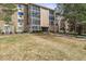 Three-story condo building with glass-enclosed patios and a large grass lawn at 3022 S Wheeling Way # 407, Aurora, CO 80014