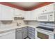 Well-lit kitchen featuring tiled backsplash, white appliances, and ample counter space at 3022 S Wheeling Way # 407, Aurora, CO 80014