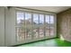 The spacious sunroom has natural light provided by wall to wall windows and a green floor at 3022 S Wheeling Way # 407, Aurora, CO 80014