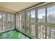The spacious sunroom has natural light provided by wall to wall windows and a green floor at 3022 S Wheeling Way # 407, Aurora, CO 80014