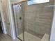 Bathroom shower with glass door, tiled walls, and built-in seating at 17146 W 92Nd Loop, Arvada, CO 80007