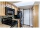 Kitchen with wood cabinets, black appliances, and skylight at 1869 S Union Blvd, Lakewood, CO 80228