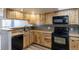 Kitchen with wood cabinets, black appliances, and tile backsplash at 1869 S Union Blvd, Lakewood, CO 80228