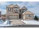 Two-story house with stone accents and a three-car garage, snow on the ground at 10535 Starglow Ct, Highlands Ranch, CO 80126