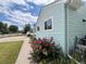 Charming exterior view with light-blue siding, flower garden, and well-maintained lawn and sidewalk at 2285 S Knox Ct, Denver, CO 80219