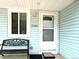 Close-up of a welcoming front porch with a bench, house number, and white-trimmed door at 2285 S Knox Ct, Denver, CO 80219