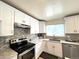 Modern kitchen featuring stainless steel appliances and sleek white cabinetry at 2285 S Knox Ct, Denver, CO 80219
