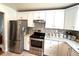 Bright kitchen with white cabinets, stainless steel appliances, and granite countertops at 2285 S Knox Ct, Denver, CO 80219