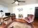 Bright living room featuring hardwood floors, a comfortable armchair, and stylish decor at 2285 S Knox Ct, Denver, CO 80219