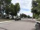 Neighborhood street scene with mature trees lining the road and well-kept front yards and sidewalks at 2285 S Knox Ct, Denver, CO 80219
