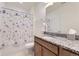 Clean bathroom with granite countertop, ample lighting, and a shower with a floral curtain at 23688 E Ida Dr # E, Aurora, CO 80016