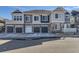 Modern townhome exterior with gray siding, stone accents, and individual garages, showcasing contemporary design at 23688 E Ida Dr # E, Aurora, CO 80016