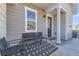 Inviting front porch with seating area, neutral siding, and a stylish front door at 23688 E Ida Dr # E, Aurora, CO 80016