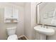 Chic half bathroom features pedestal sink, large mirror, storage cabinet, and wood-look flooring at 8183 S Yosemite Ct, Centennial, CO 80112