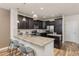 Modern kitchen with dark cabinetry, granite countertops, stainless steel appliances, and barstool seating at 8183 S Yosemite Ct, Centennial, CO 80112
