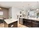 Open-concept kitchen featuring dark cabinets, stainless appliances, granite countertops, and breakfast bar seating at 8183 S Yosemite Ct, Centennial, CO 80112