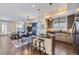 Open-concept kitchen flowing into the living area, complete with a breakfast bar, modern appliances, and hardwood floors at 2235 S Cherokee St, Denver, CO 80223