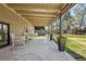 Covered back porch with outdoor seating overlooking the landscaped backyard at 1485 S Jasmine Way, Denver, CO 80224