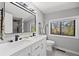 Bright bathroom featuring a double vanity, modern fixtures, and a large mirror with stylish lighting at 1485 S Jasmine Way, Denver, CO 80224