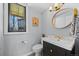 Bathroom features modern vanity with stylish fixtures, gold mirror, and a window with natural light at 1485 S Jasmine Way, Denver, CO 80224