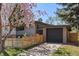 A modern home featuring a detached garage with wood accents and a well-maintained lawn at 1485 S Jasmine Way, Denver, CO 80224