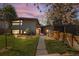 Modern home with wood siding, fresh landscaping, and a walkway leading to the front door at twilight at 1485 S Jasmine Way, Denver, CO 80224